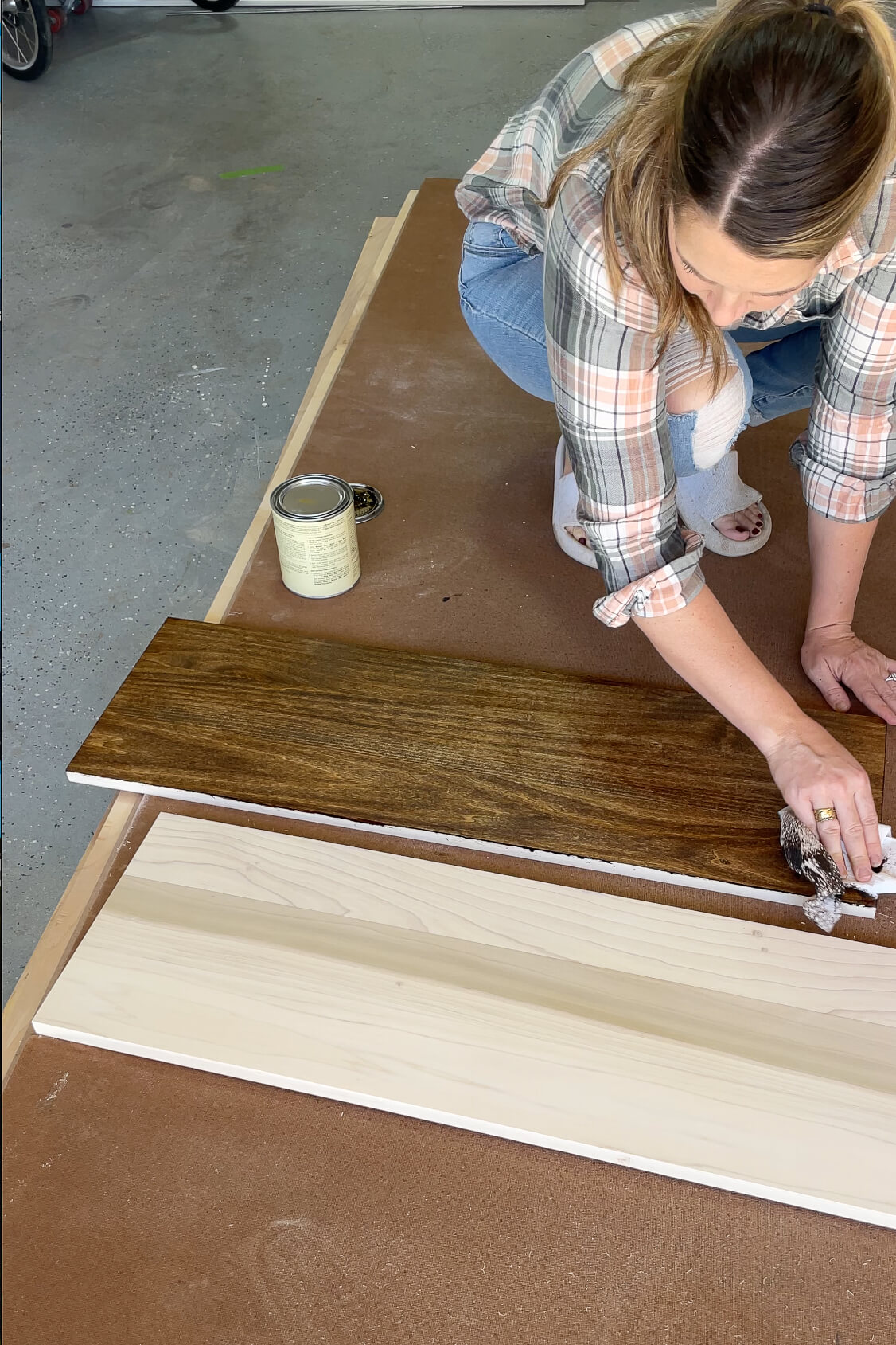 Wiping stain off of a shelf with a paper towel. 